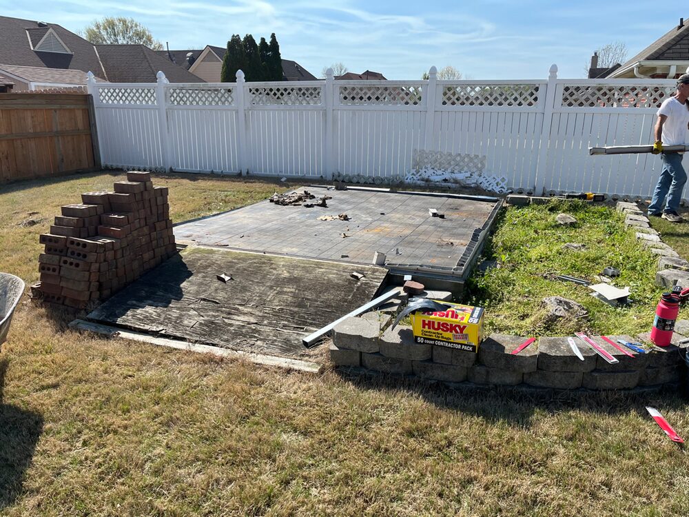 The same corner of the yard with the shed gone and only its bare slab left