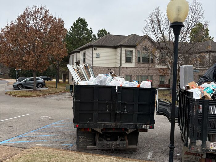 A loaded truck and container standing at an apartment complex